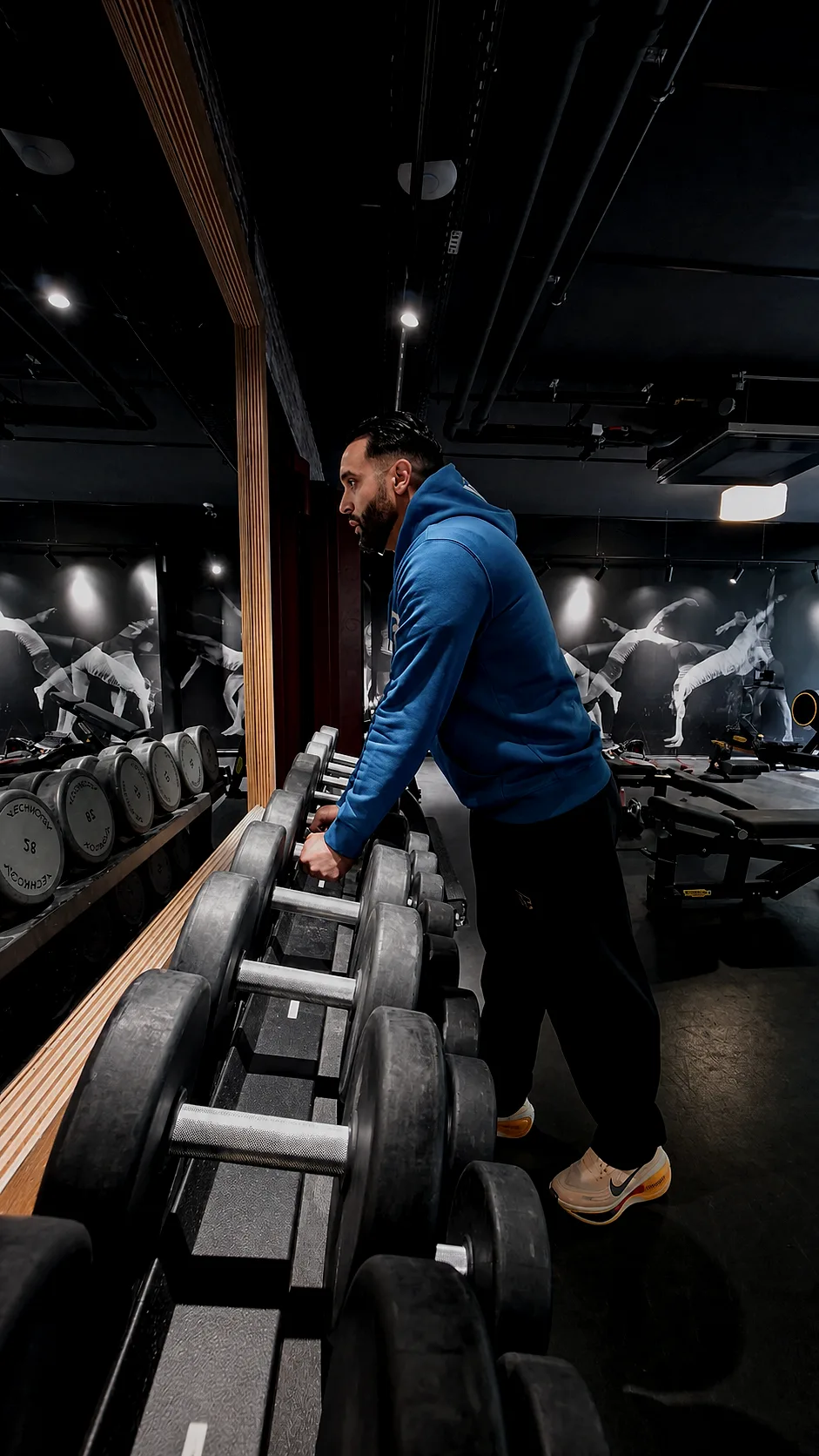 Wajdi observe le rack d’haltères à Evo Fitness Champel, Genève