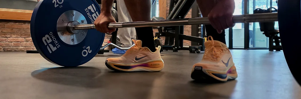 Mise en place sur un soulevé de terre, barre chargée à 20 kilos, salle Evo Fitness à Champel